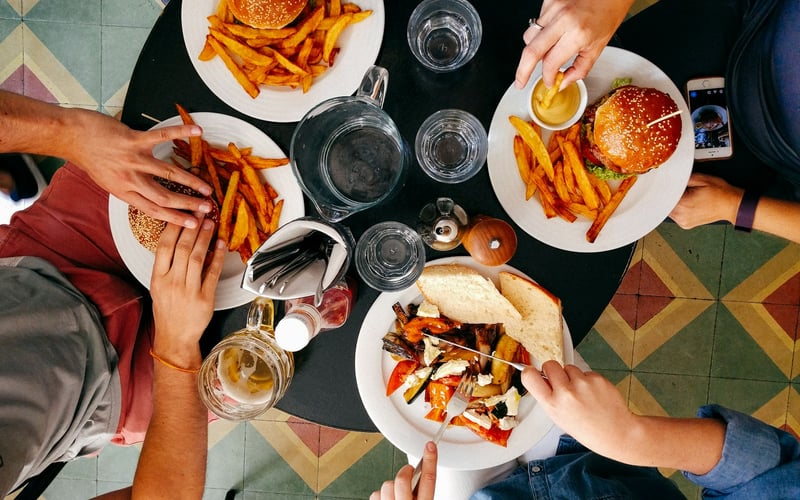 Four people sharing plates around a small table